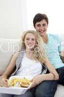 Teen couple eating burgers and fries
