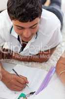 Teen guy studying on the floor with his friends