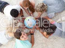 Group of teenagers on the floor examining a terrestrial world