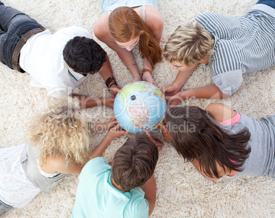 Group of teenagers on the floor examining a terrestrial world