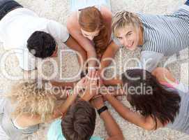 Teenagers lying on the floor with hands together