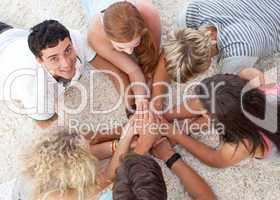 Teenagers lying on the ground with hands together