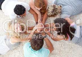 Teenagers lying on the floor with hands together