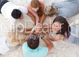 High angle of teenagers lying on the floor with hands together