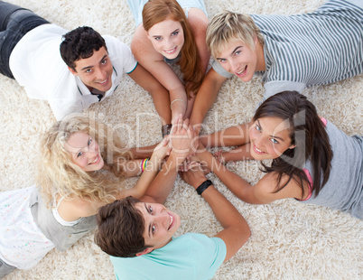 Friends lying on the floor with hands together