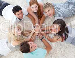 Friends lying on the floor with hands together