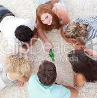 Group of friends playing spin the bottle on the floor