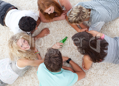 Group of teenagers playing with a bottle on the floor