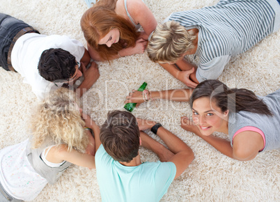 Group of friends playing spin the bottle