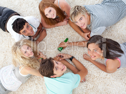 Group of teenagers playing spin the bottle
