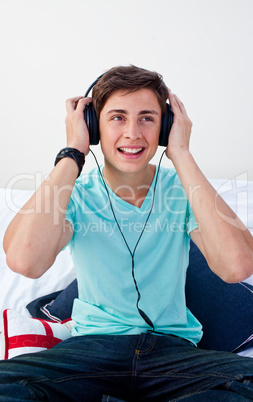 A teenage guy sitting on his bed listening to the music