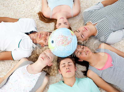 Teenagers sleeping on the floor with a terrestrial globe in the