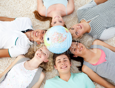 Teenagers on the floor with a terrestrial globe in the center