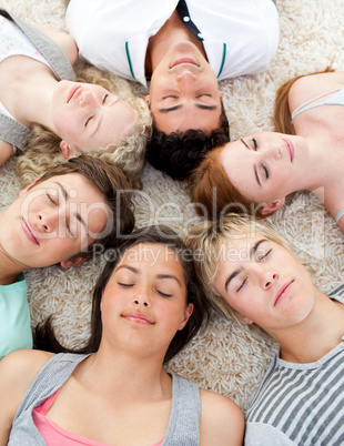 Teenagers with their heads together sleeping on the ground