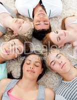 Teenagers with their heads together sleeping on the ground