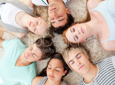 High angle of teenagers with their heads together sleeping on th