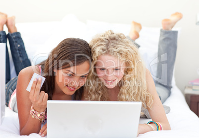 Friend girls shopping online in a bedroom