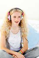 Beautiful teenager listening to the music on his bed