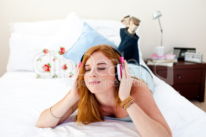 Beautiful teenager listening to the music on his bed