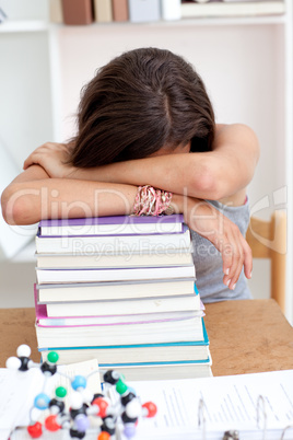 Tired teeenager sleeping on books