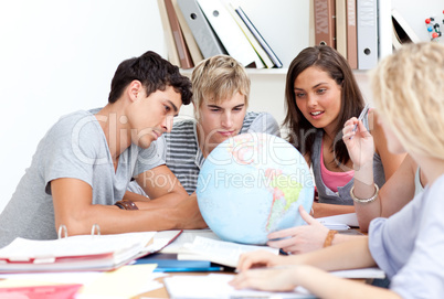 Teenagers in a library working with a terrestrial globe