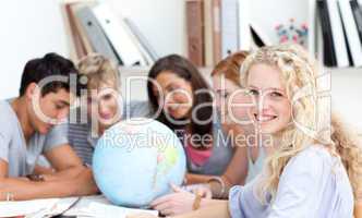 Teenagers in a library working with a terrestrial globe