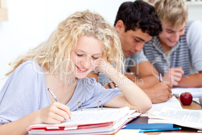 Teen girl studying in the library with her friends