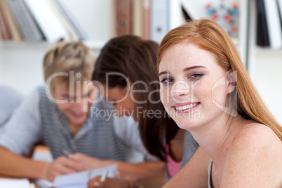 Teen girl studying in the library with her friends