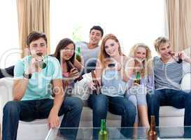 Friends drinking beer at home and watching tv