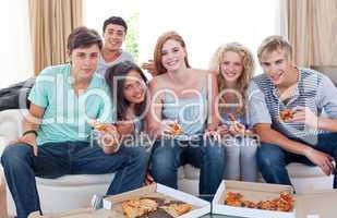 Adolescents eating pizza at home