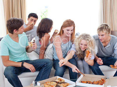 Teenagers eating pizza at home