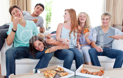 Teenagers eating pizza at home