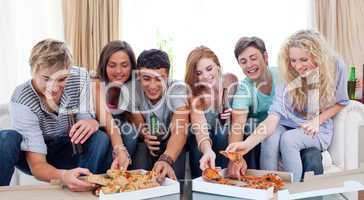 Teenagers eating pizza at home