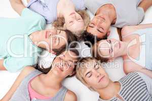 Teens sleeping on floor with heads together