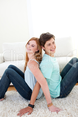 A couple of teenagers sitting on the floor