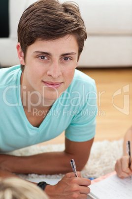 Teen guy studying on the floor with his friends