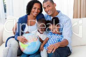 Afro-american family holding a terrestrial globe