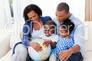 Happy family holding a terrestrial globe