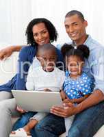 Smiling Afro-american family using a laptop