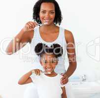 Mother and her daughter brushing their teeth