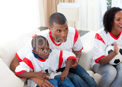 Happy family watching a football match