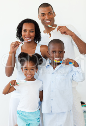 Smiling family brushing their teeth