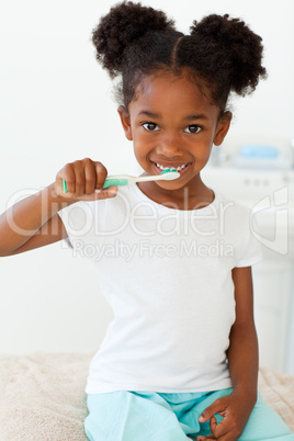Portrait of a smiling little girl brushing her teeth