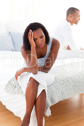 Angry couple sitting on bed separately
