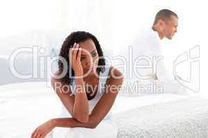 Upset young couple sitting on bed separately