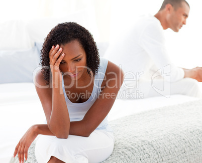 Upset couple sitting on bed separately