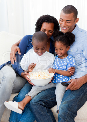 Happy family eating popcorn and watching TV