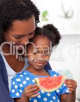 Beautiful girl eating watermelon with her mother