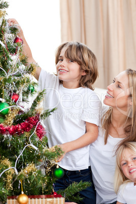 Mother and her children decorating a Christmas tree