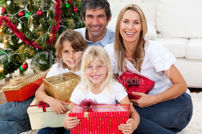 Smiling family holding Christmas presents